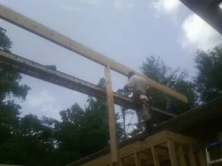 Carpenter setting a ridge beam over a new addition frame — Ice Dam Removal by Roofing Brothers in Collierville