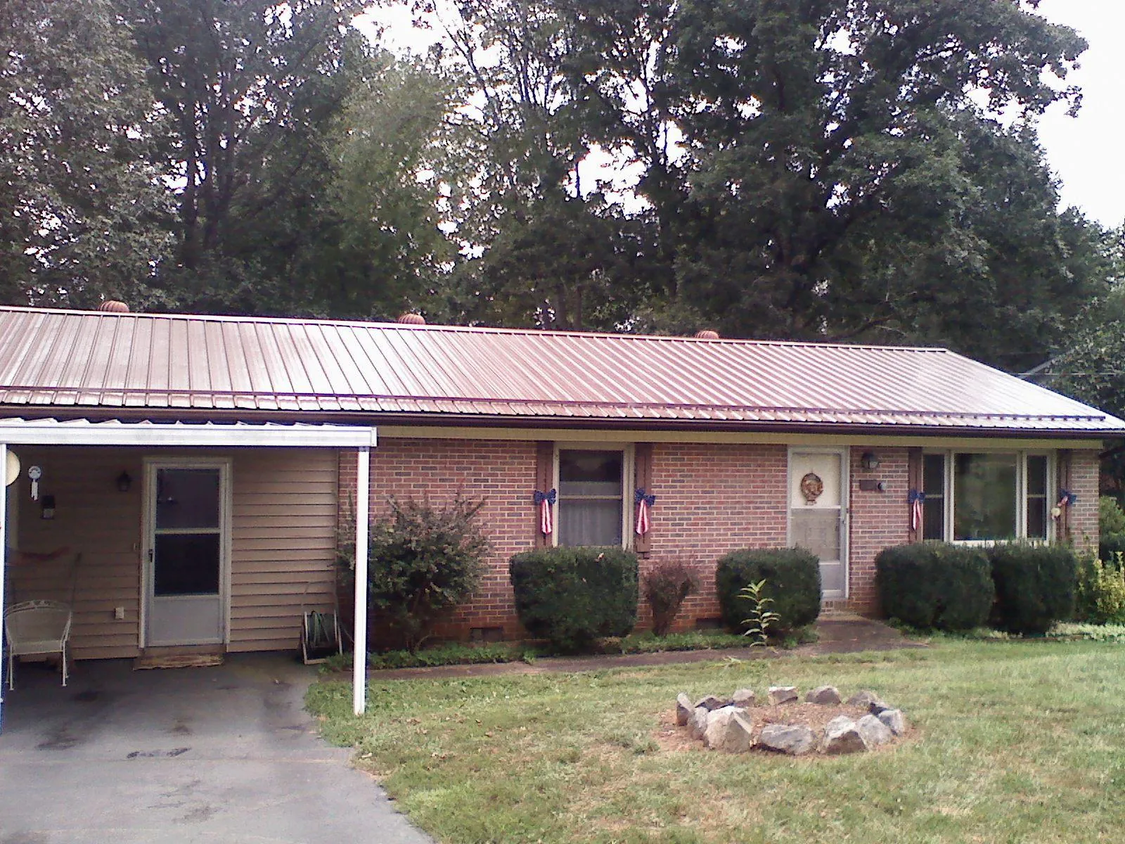 Bronze metal roof and carport on a brick ranch home — Roof Repair work by our crew in Collierville